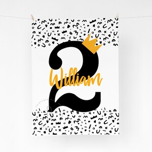 Puede incluir: Pancarta de cumplea&ntilde;os imprimible en blanco y negro con un gran n&uacute;mero dos negro con una corona dorada en la parte superior. El nombre William est&aacute; escrito en letras doradas en el n&uacute;mero dos. El fondo est&aacute; lleno de formas geom&eacute;tricas en blanco y negro.