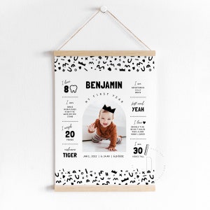 May include: Black and white printable poster with a photo of a baby boy in a crown. The poster includes details about the baby's first year, including their weight, height, first word, and favorite things. The poster is decorated with a black and white geometric pattern.