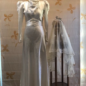 1930er Jahre Seidensatin Brokat Brautkleid mit Wachs Blumen Dekor.