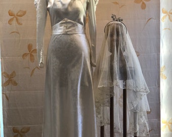 Vestido de novia de brocado de raso de seda de los años 30 con decoración de flores de cera.