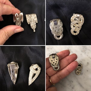 May include: Four vintage silver tone rhinestone dress clips. Two clips are shaped like a teardrop with a pointed bottom. The other two clips are shaped like a heart with a pointed bottom. All clips have a silver tone metal backing.