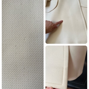 May include: A close-up of a white coat with a herringbone pattern. The coat has a pocket on the front and a seam down the side. The fabric is soft and smooth.