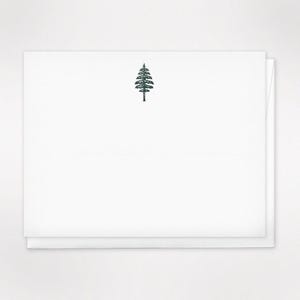 May include: A white card with a simple black silhouette of a pine tree in the center.