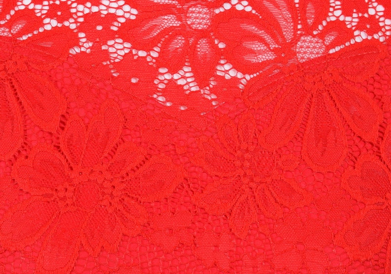 May include: Red lace fabric with a floral pattern. The lace is delicate and intricate, with a soft, flowing texture.