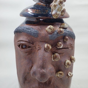Man with soap in his eyes, sculpture on vase