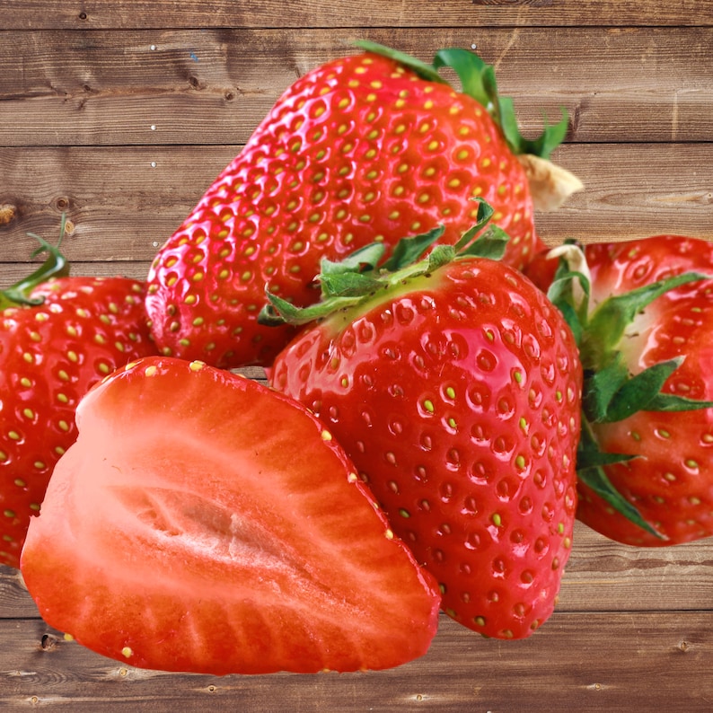 May include: Close-up of five red strawberries, some whole and one cut in half, on a wooden surface.