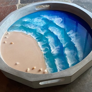 Round gray-wash wood serving tray with resin beach scene inlay and seashells.