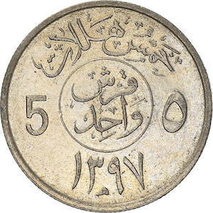 May include: A silver-colored coin with Arabic script and the number 5 on the left side. The coin has a circular design with intricate details and a worn appearance, suggesting it is an older coin.