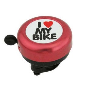May include: A red bicycle bell with the text "I ❤️ MY BIKE" in black letters and a red heart on a white background. The bell has a black lever and a black base, designed to attach to a bicycle handlebar.