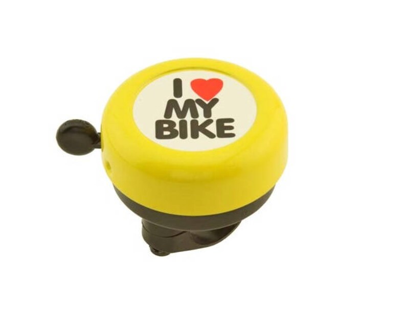 May include: A yellow bicycle bell with a black lever and base. The bell has a white circle with the words "I MY BIKE" and a red heart. The bell is designed to be mounted on a bicycle handlebar.