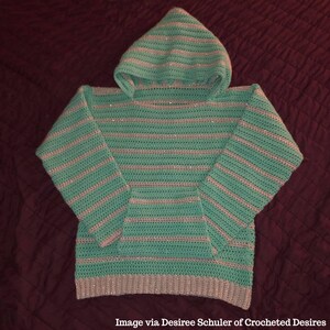 May include: A teal and silver striped crocheted hooded sweater with a pocket on the front.