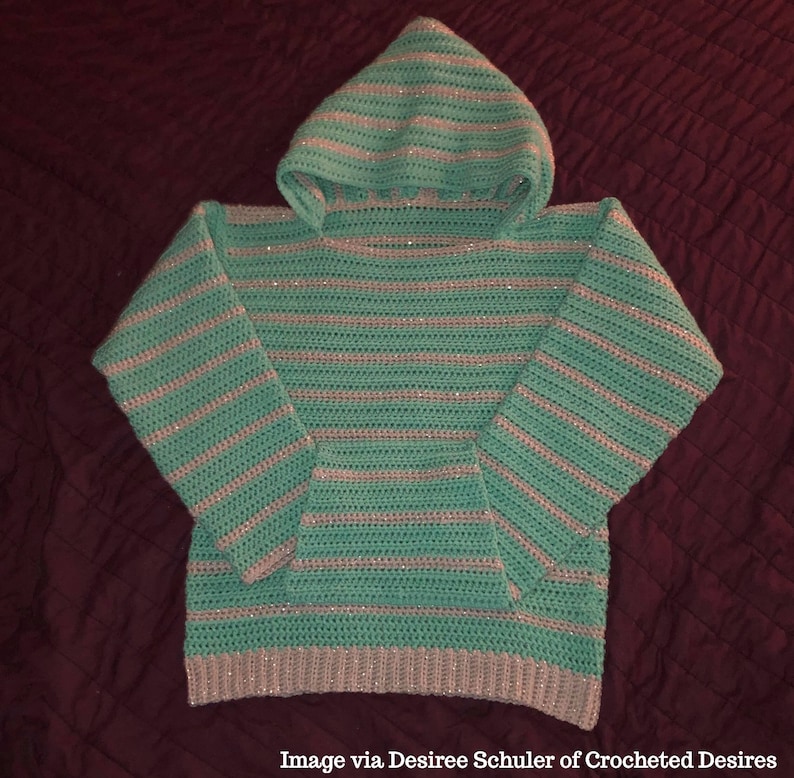 May include: A teal and silver striped crocheted hooded sweater with a pocket on the front.