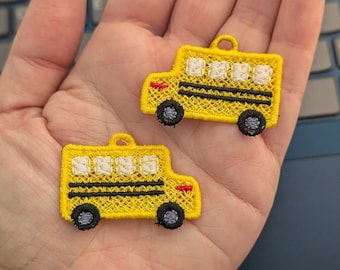 Pode incluir: Dois patches de ônibus escolar de feltro bordado amarelo com detalhes em preto e branco. Os patches estão em uma mão.