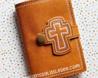 May include: A brown leather journal cover with a white cross design and the text "DesignsByLittleBee.com".