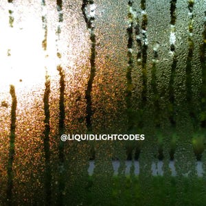 Könnte beinhalten: Nahaufnahme eines Fensters mit Kondenswasser auf dem Glas. Die Sonne scheint durch das Fenster und erzeugt einen warmen, goldenen Schein. Das Kondenswasser auf dem Glas erzeugt einen verschwommenen, abstrakten Effekt. Der Text "@LIQUIDLIGHTCODES" ist im unteren mittleren Bereich des Bildes sichtbar.