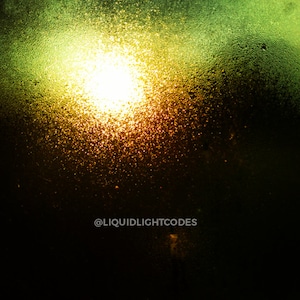 Puede incluir: Una imagen borrosa de una luz brillante que brilla a través de una ventana cubierta de gotas de agua. La luz está rodeada de un brillo verde, y el fondo es oscuro.