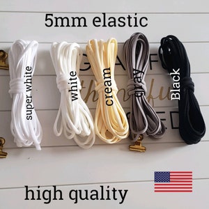 May include: Five spools of 5mm elastic in super white, white, cream, gray, and black. The text "5mm elastic" and "high quality" are printed below the spools. An American flag is in the bottom right corner.