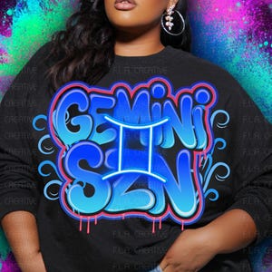 Op de afbeelding: Zwart sweatshirt met de woorden "GEMINI SZN" in blauwe graffiti-letters. Het ontwerp bevat het sterrenbeeld Tweelingen. De achtergrond heeft een kleurrijk, abstract ontwerp met paarse, blauwe en groene spetters.
