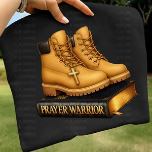 A pair of yellow boots with a cross on top of a black book, with the title "PRAYER WARRIOR" printed on the book.