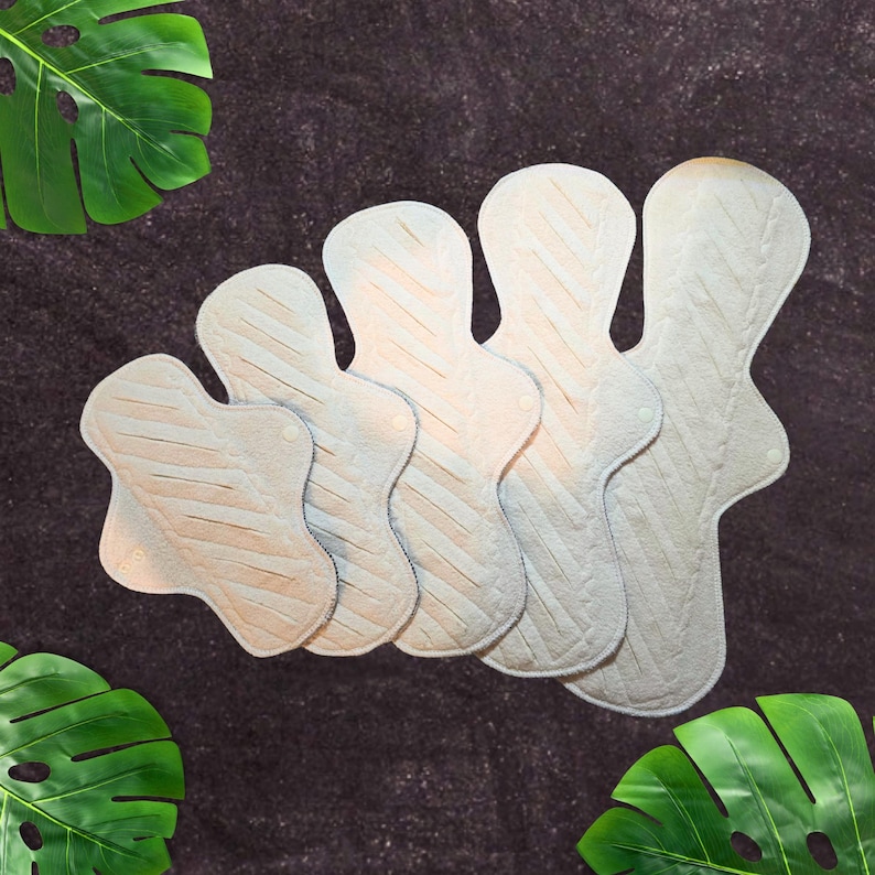 a group of undyed organic cotton pads made with undyed organic cotton sherpa with slits across the top gusher pad style