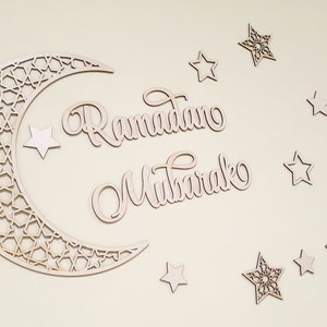May include: Wooden cutout of a crescent moon with a geometric pattern, the words "Ramadan Mubarak" and several stars.