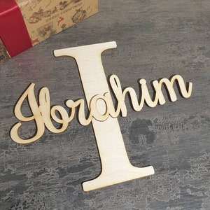 Puede incluir: Corte de madera del nombre "Ibrahim" con una gran letra "I" de madera delante.