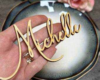 Puede incluir: Tarjeta de lugar de madera con el nombre "Michelle" escrito en cursiva.