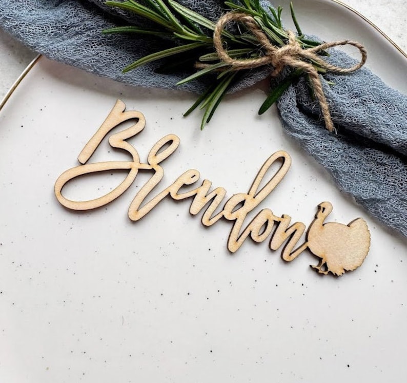 May include: Wooden Thanksgiving place card with the name "Brendan" and a turkey silhouette.