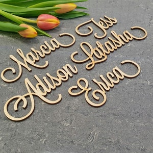 May include: Wooden name signs with the names Marcia, Addison, Jess, Latasha, and Erica written in cursive script.