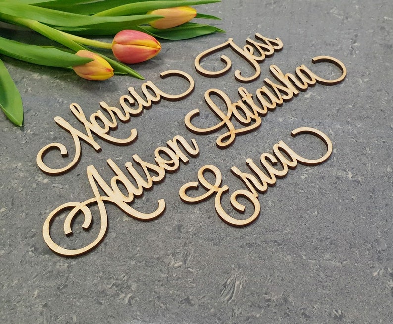 May include: Wooden name signs with the names Marcia, Addison, Jess, Latasha, and Erica written in cursive script.