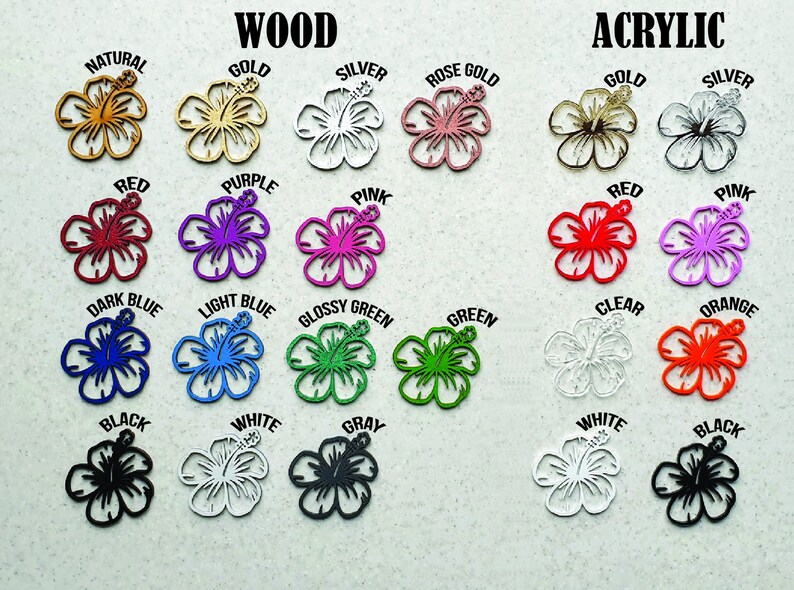 May include: A variety of laser-cut hibiscus flower shapes in wood and acrylic. Colors include natural, gold, silver, red, purple, pink, dark blue, light blue, glossy green, green, black, white, gray, clear, and orange. The word "WOOD" and "ACRYLIC" are at the top.