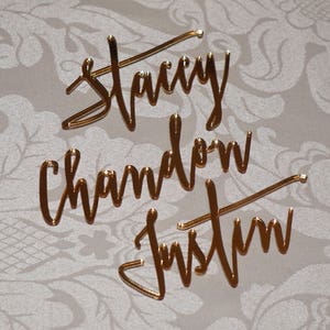 May include: Gold mirror acrylic names, "Stacy", "Chandon", and "Justin" in a cursive script font.
