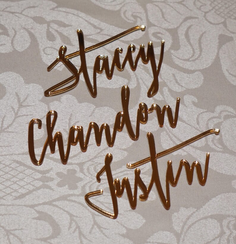 May include: Gold mirror acrylic names, "Stacy", "Chandon", and "Justin" in a cursive script font.