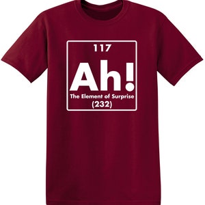 May include: A maroon t-shirt with a white graphic of a periodic table element. The element is labeled "Ah!" with the text "The Element of Surprise (232)".