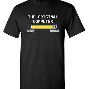 May include: Black t-shirt with the text "THE ORIGINAL COMPUTER" and a yellow pencil with "PRINT" and "DELETE" labels on either end.