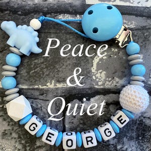 Clip para chupete personalizado, cadena para chupete de madera, clip para chupete de madera, dinosaurio de silicona, clip para chupete para niños azul y gris, diseño de letras gruesas.