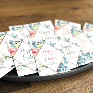 May include: A stack of white cards with a gold diamond frame and floral design. The cards say "Happy Easter" and "Love The White Family".