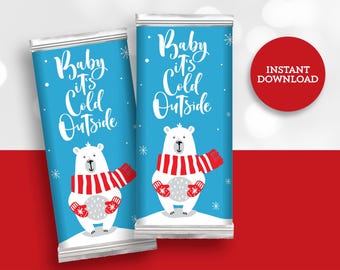 May include: Two printable chocolate bar wrappers featuring a white polar bear wearing a red and white scarf and holding a snowball. The wrappers have a blue background with white snowflakes and the text "Baby it's Cold Outside".