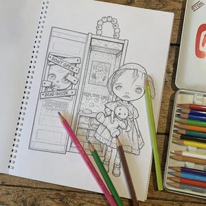 Peut inclure: Une page de cahier de coloriage &agrave; spirales avec une illustration au trait d'un enfant tenant un ours en peluche &agrave; c&ocirc;t&eacute; d'un casier portant le texte DONT OPEN DEAD INSIDE ZOMBIES. Trois crayons de couleur rose, vert et marron sont pos&eacute;s.