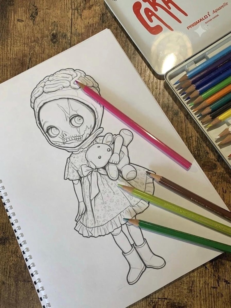 Peut inclure: Un dessin au trait noir et blanc sur une page de carnet &agrave; spirales repr&eacute;sentant une poup&eacute;e avec une coiffe en forme de cerveau, un visage squelettique et une robe, tenant un petit ours en peluche, accompagn&eacute; de quatre crayons de couleur.
