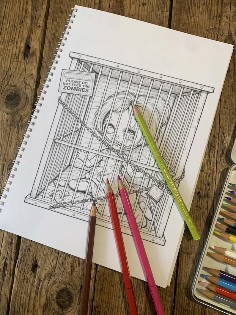Peut inclure: Une page de cahier de coloriage &agrave; spirales pr&eacute;sentant une illustration au trait noir et blanc d'une poup&eacute;e enferm&eacute;e dans une cage en m&eacute;tal. Un panneau sur la cage indique WARNING PLEASE DO NOT FEED THE ZOMBIES. Trois crayons de couleur brun, rouge et rose.