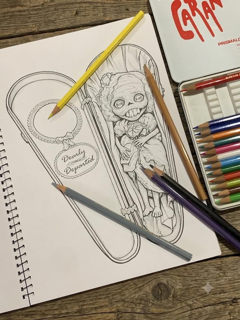 May include: A black and white line art drawing in a spiral notebook featuring a character with large eyes and teeth inside a coffin, with the text Dearly Departed. Colored pencils in yellow, tan, purple, and black are placed on the page.