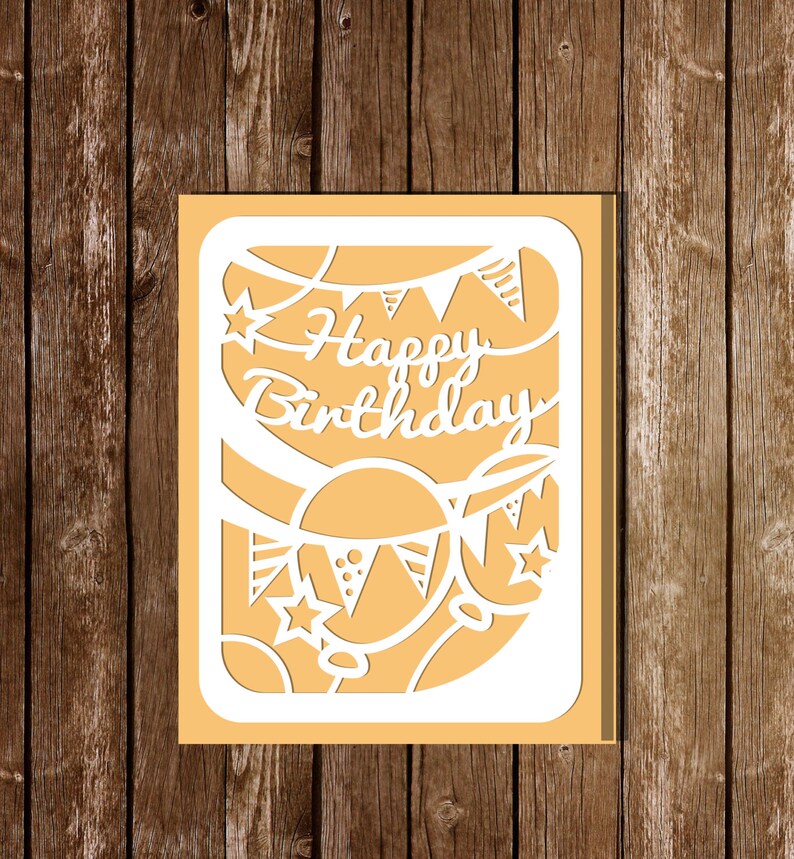 Pode incluir: Um cart&atilde;o branco com um design recortado que apresenta bal&otilde;es, estrelas e uma faixa que diz "Feliz anivers&aacute;rio".