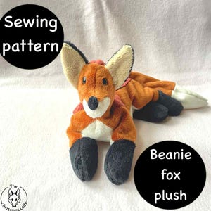 Könnte beinhalten: Ein Plüschfuchs-Spielzeug mit orange, weiß, schwarz und hellbraun. Der Fuchs hat große Ohren und einen langen Körper. Die Texte "Sewing pattern" und "Beanie fox plush" sind in schwarzen Kreisen.