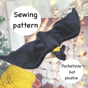 May include: A black plush bat with yellow detailing is displayed. The bat features large wings and a small head. The text "Sewing pattern" and "Pocketsize bat plushie" are in white circles.