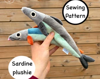 May include: Two plush sardine toys in shades of gray, blue, green, and orange. One sardine is positioned on top of the other. The image includes the text "Sardine plushie" and "Sewing Pattern".