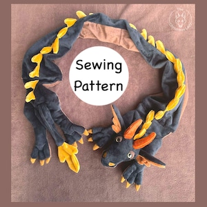 Könnte beinhalten: Ein Schnittmuster für einen Plüschdrachen in Dunkelblau, Braun und Gelb. Der Drache hat einen detaillierten Kopf, Flügel und Krallen. Der Text "Sewing Pattern" befindet sich in einem weißen Kreis.