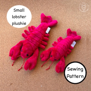 Puede incluir: Dos juguetes de langosta de peluche de color rosa brillante con ojos negros y antenas delgadas. La imagen incluye superposiciones de texto circulares blancas que dicen Small lobster plushie y Sewing Pattern, junto con un pequeño logotipo en la esquina superior derecha.