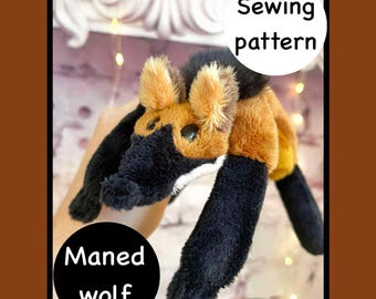 Puede incluir: Un peluche de lobo de crin con nariz, orejas y patas negras, y cuerpo marrón y beige. Los textos "Sewing pattern" y "Maned wolf" están en círculos blancos.