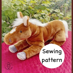 May include: A plush brown and white horse toy with a white mane and tail. The horse is lying down on a pink surface. The text "Sewing pattern" is in a white circle.
